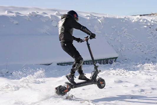 Rider performing wheelie on Kukirin G2 Master electric scooter in deep snow