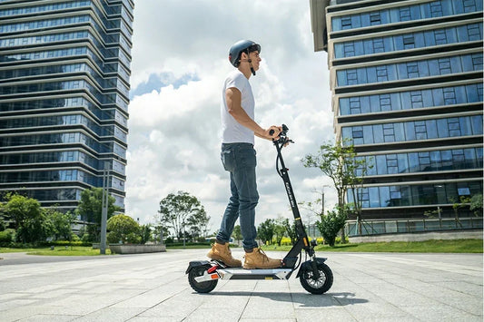 Man with helmet riding Kukirin M4 Max electric scooter in modern business district plaza