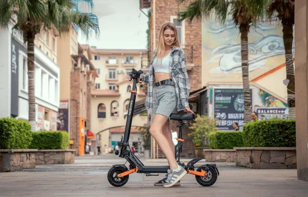 Kukirin G2 Pro foldable electric scooter with seat, held by a woman in a sunlit European-style town.